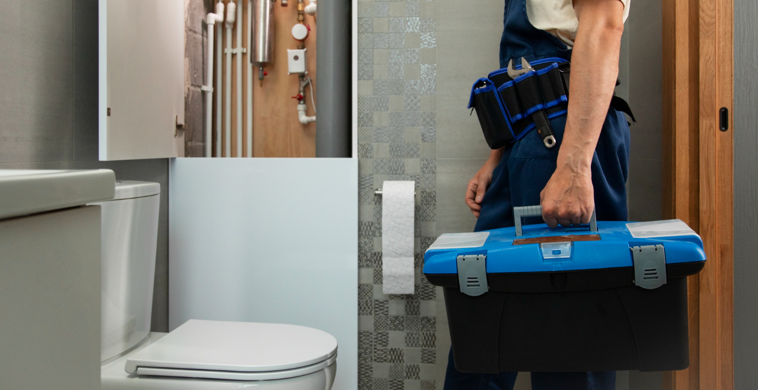 Técnico en fontanería, entrando a un lavabo con su kit de trabajo Nuestra misión